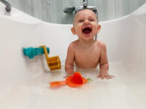 Baby in sink with toys